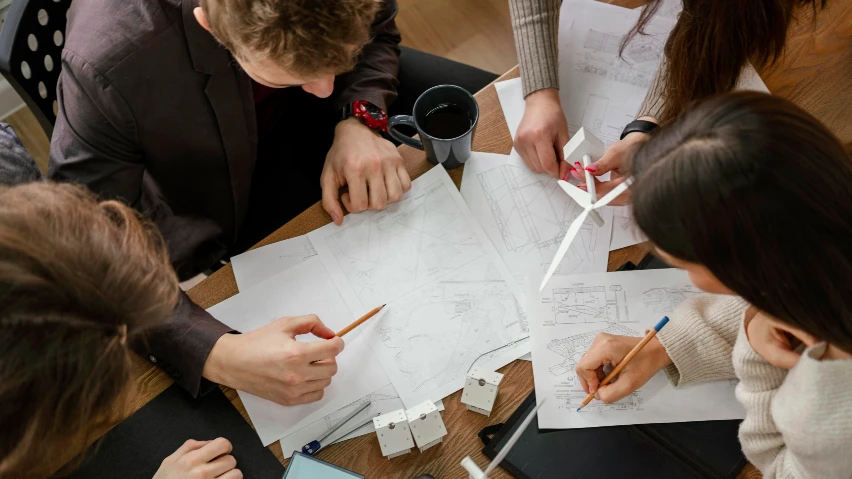 A group of people looking at some papers on a table